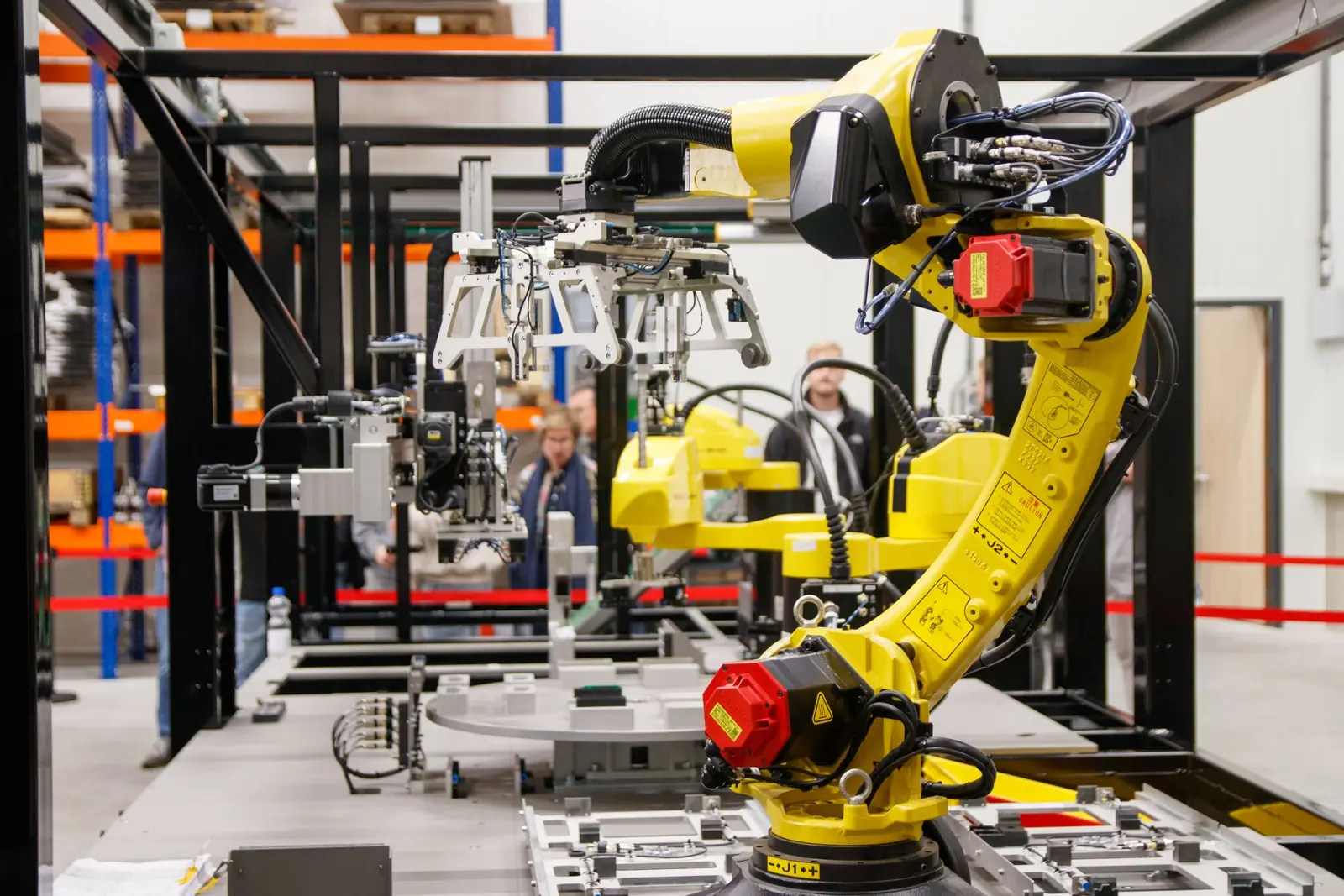Gelber Industrieroboter an einer Montagezelle in einer Fertigungshalle